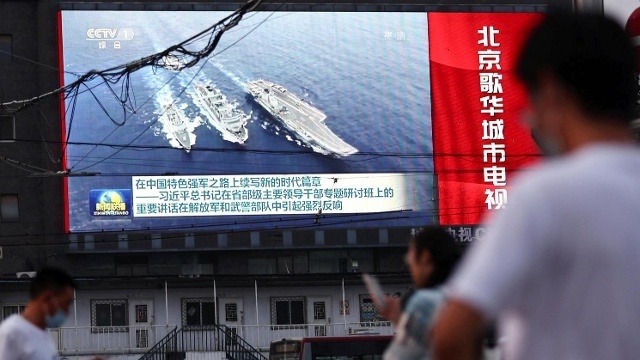 Ein bildschirm in beijing zeigt schiffe der chinesischen marine das land reagiert mit drohungen auf den taiwan besuch von nancy pelosi